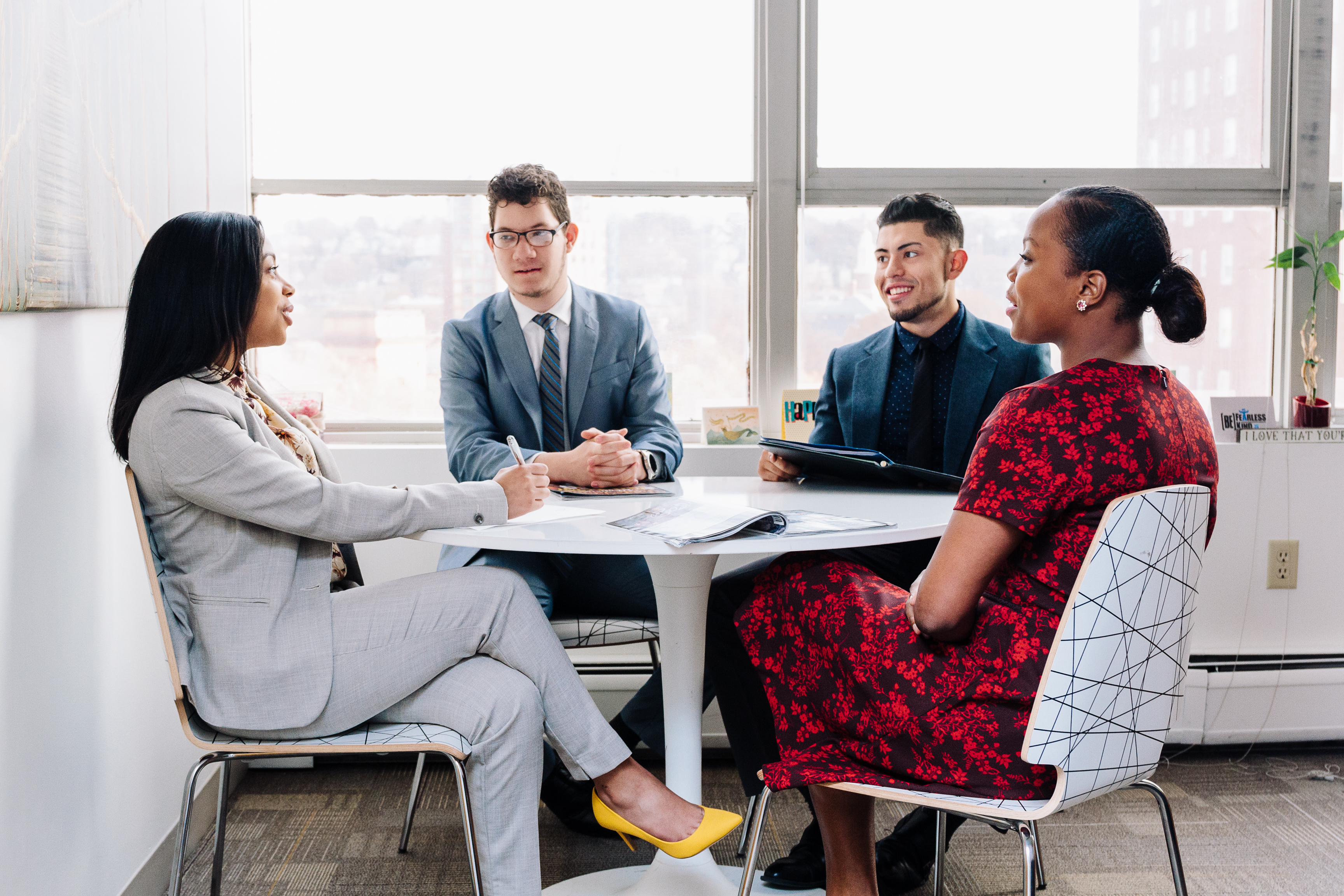 Image of young adults conversing around a table