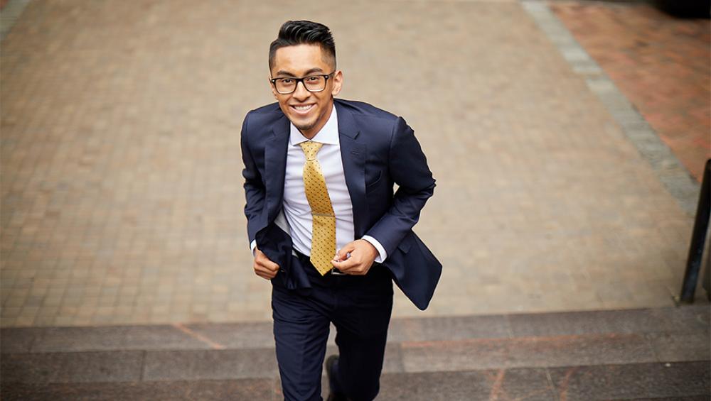 An alum of the program smiling and running up a set of stairs towards the camera