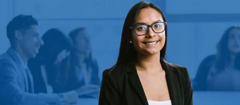 A woman with glasses and black blazer smiling at the camera